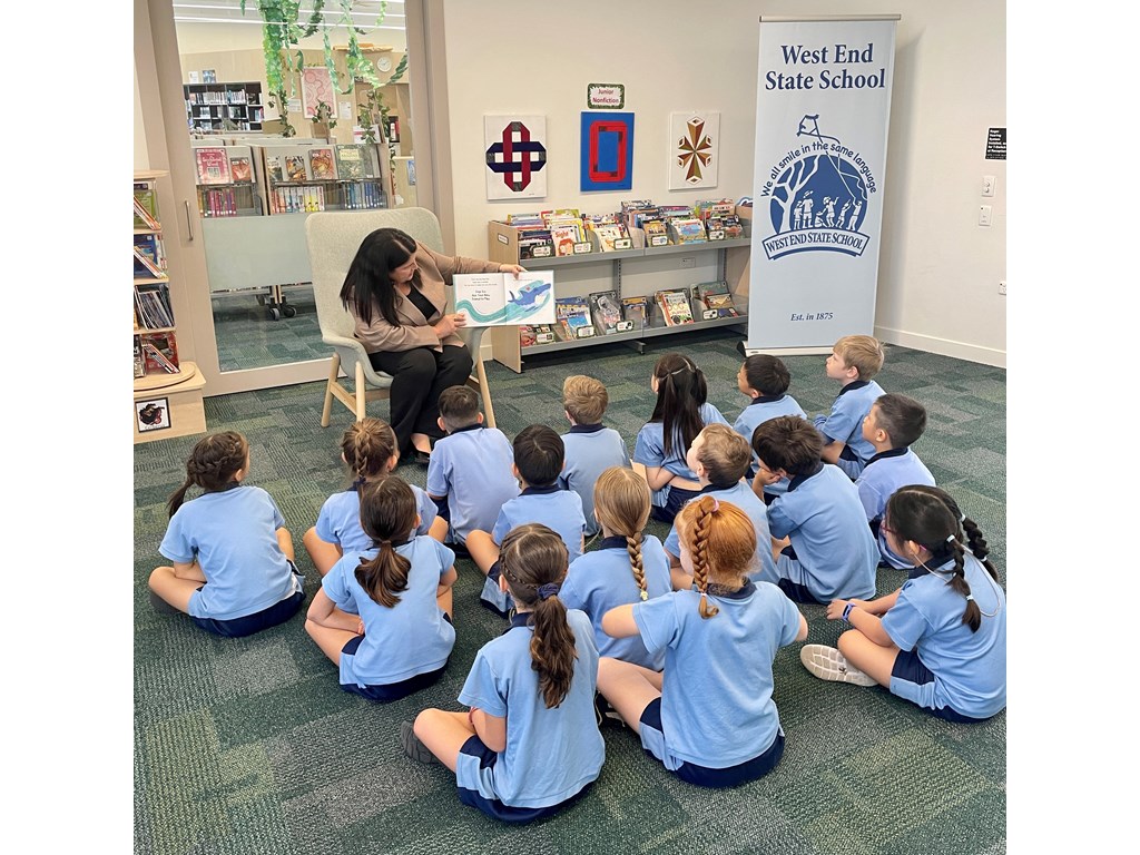 Minister Grace reading to students at West End State School