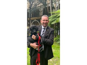 Disability Services Minister Craig Crawford with a trainee Seeing Eye puppy at the graduation ceremony at Parliament House