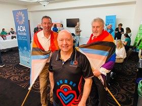 Seniors Minister Craig Crawford, LGBTI Health's Gary Hubble and Council on The Ageing chief executive Mark Tucker-Evans fly the flag at the LGBTIQ+ Seniors Expo in Cairns.